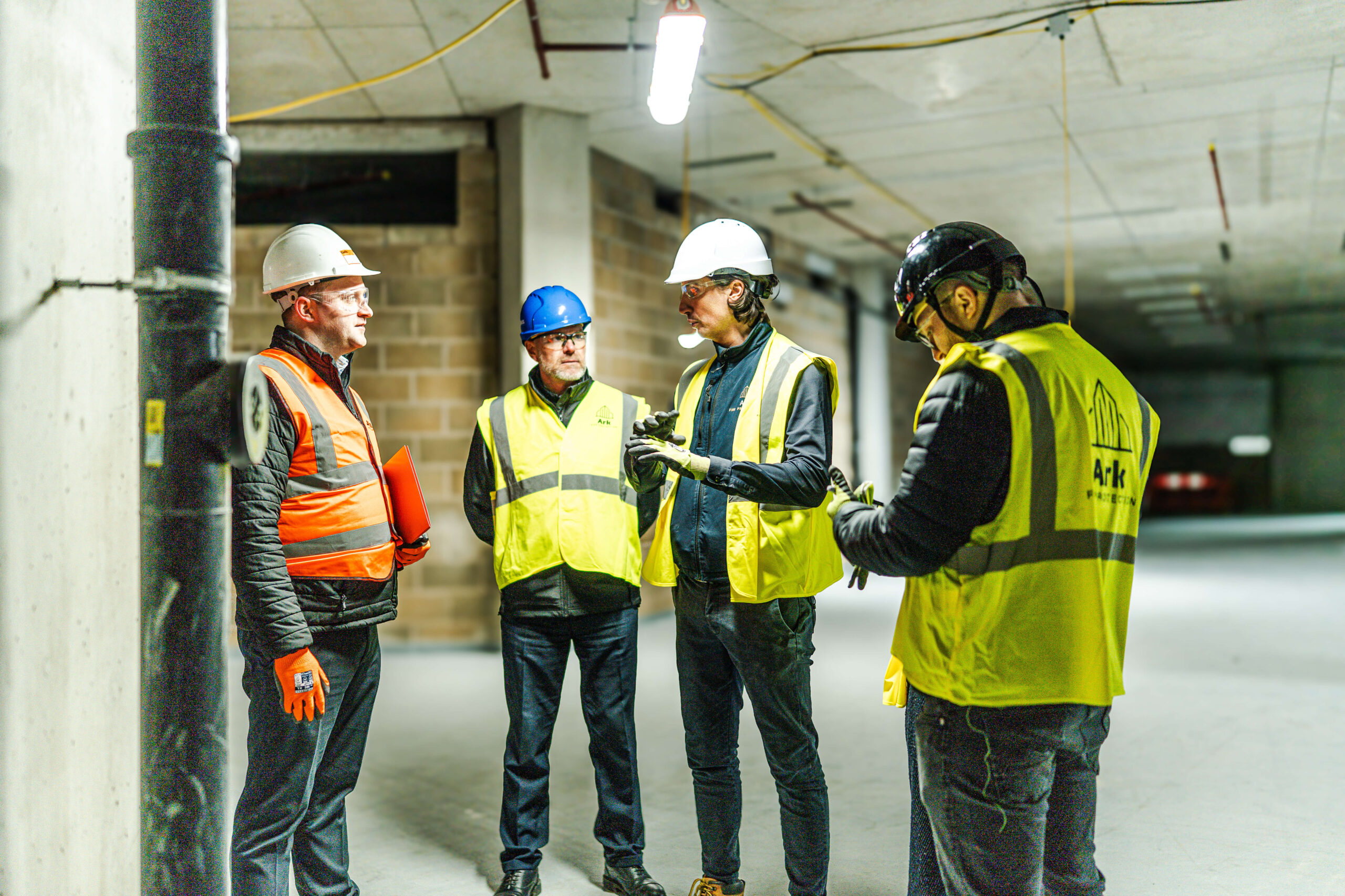 Ark Team in full safety equipment discuss on a commercial site