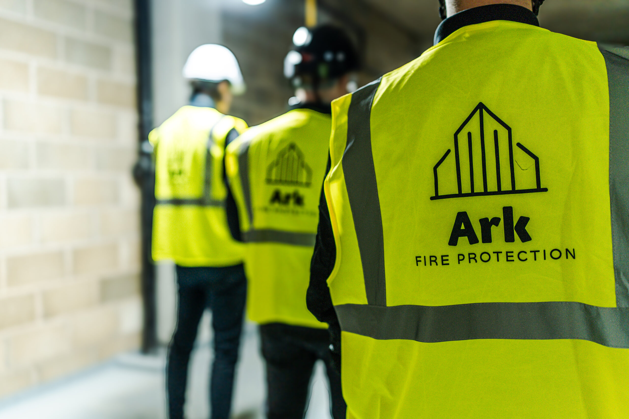 3 members of the Ark team on site wearing branded high-vis jackets.
